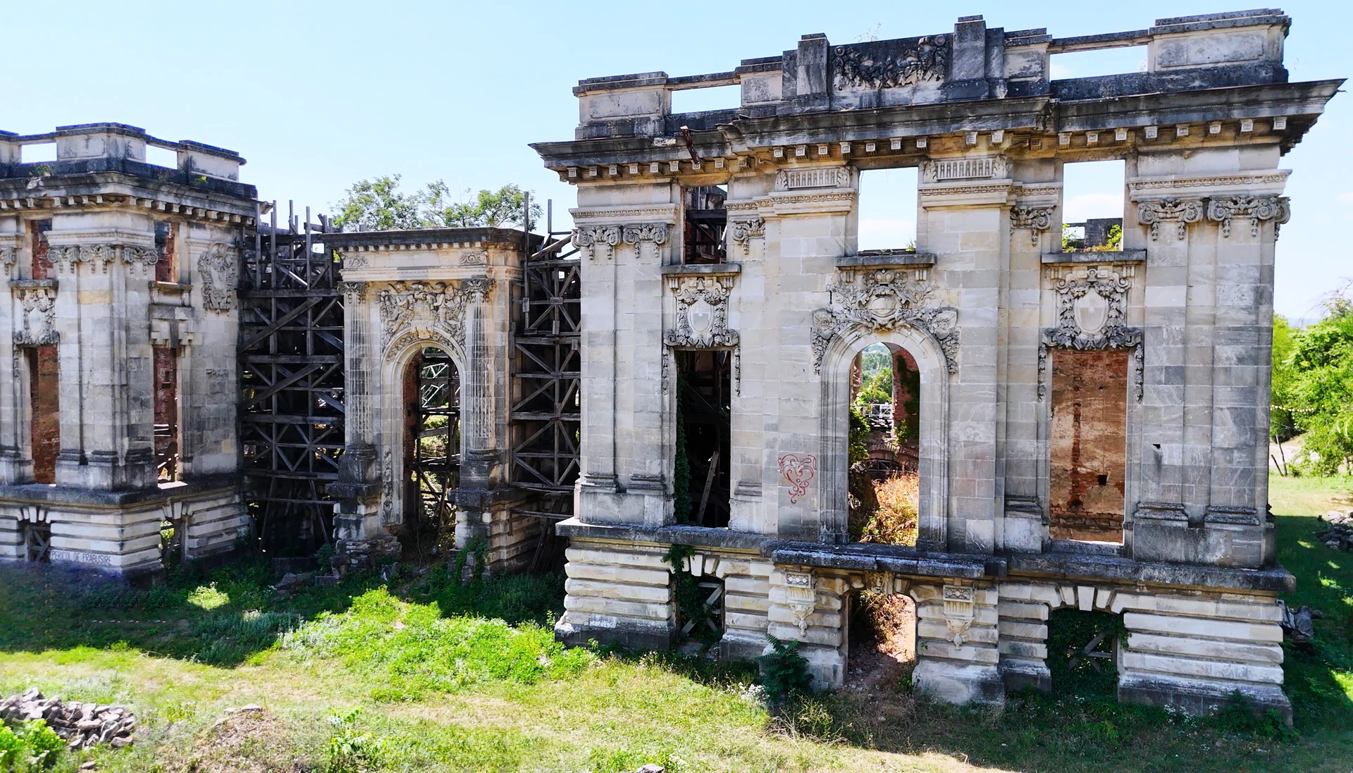 The ruined stone facade of an abandoned manor.